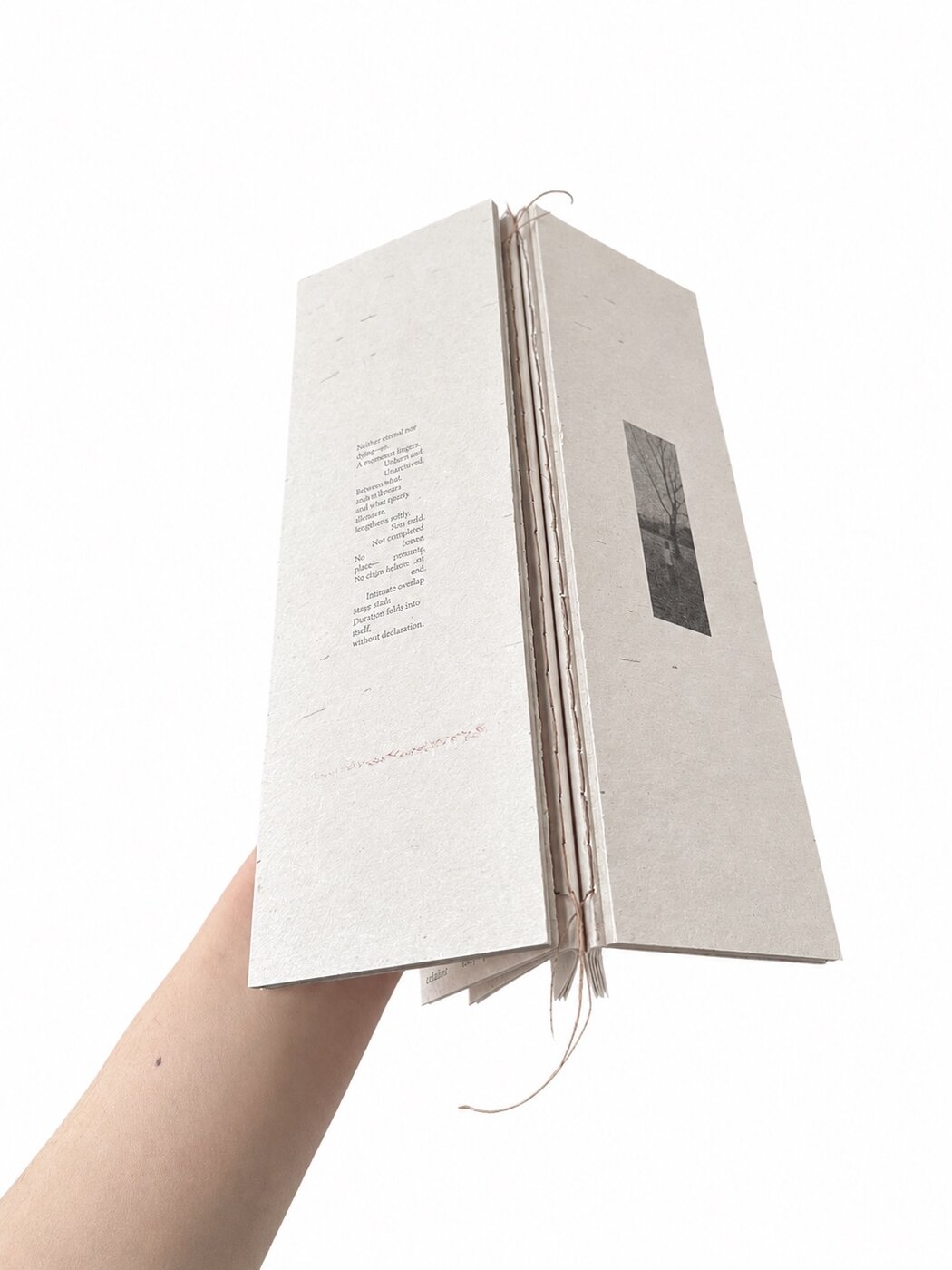 The closed book seen from the spine — exposed butterfly stitching visible along the edge.